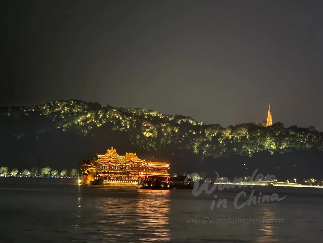 Croisière nocturne sur le lac de l’Ouest avec reflet des lumières de la ville.